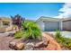 Landscaped front yard leading to a single-story home with a two-car garage at 7029 Bocaire Dr, Las Vegas, NV 89131