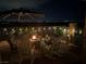 Relaxing nighttime patio with comfortable seating, rocking chairs, string lights, and a cozy fire pit at 7029 Bocaire Dr, Las Vegas, NV 89131