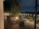 Comfortable nighttime patio featuring lounge chairs and a cozy fire pit with string lights at 7029 Bocaire Dr, Las Vegas, NV 89131