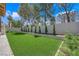 Backyard featuring lush synthetic lawn and privacy wall with landscaped border at 7813 Riviera Beach Dr, Las Vegas, NV 89128