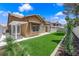 Backyard featuring synthetic grass, desert landscaping, and a patio at 7813 Riviera Beach Dr, Las Vegas, NV 89128