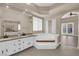 Beautiful bathroom with a soaking tub, dual sinks, and glass doors leading to the backyard at 7813 Riviera Beach Dr, Las Vegas, NV 89128