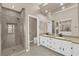 Modern bathroom with a tiled shower, dual sinks, and vanity with granite countertops at 7813 Riviera Beach Dr, Las Vegas, NV 89128