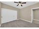 A spacious bedroom with a ceiling fan, closet, and durable gray wood-look flooring at 7813 Riviera Beach Dr, Las Vegas, NV 89128
