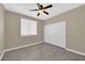 A cozy bedroom featuring a window, ceiling fan, and closet on durable gray wood-look flooring at 7813 Riviera Beach Dr, Las Vegas, NV 89128