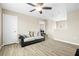 Living room with neutral walls, ceiling fan, wood-look floors, couch, and a white door at 7868 Territorial St, Las Vegas, NV 89149