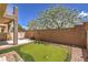 Backyard with putting green, brick wall, covered patio and seating area at 8775 Traveling Breeze Ave # 102, Las Vegas, NV 89178