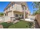 Rear exterior of home with putting green, covered patio, and fenced yard at 8775 Traveling Breeze Ave # 102, Las Vegas, NV 89178