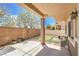 Spacious covered patio with putting green, landscaping, and brick wall at 8775 Traveling Breeze Ave # 102, Las Vegas, NV 89178