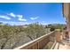Charming balcony with a view of flowering trees and mountains against a bright blue sky at 8775 Traveling Breeze Ave # 102, Las Vegas, NV 89178