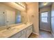 Bright bathroom featuring double sinks, ample countertop space, and a modern mirror at 8775 Traveling Breeze Ave # 102, Las Vegas, NV 89178