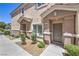 Well-maintained townhome entrance with landscaped yard and a welcoming front door at 8775 Traveling Breeze Ave # 102, Las Vegas, NV 89178