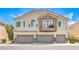 Two-story townhouse with three garages, neutral paint, and a small, charming balcony at 8775 Traveling Breeze Ave # 102, Las Vegas, NV 89178