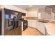 Modern kitchen with white cabinetry, black appliances, and stylish tile backsplash at 8775 Traveling Breeze Ave # 102, Las Vegas, NV 89178