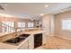 Open kitchen with stainless steel appliances and tile flooring flowing into the living space at 8775 Traveling Breeze Ave # 102, Las Vegas, NV 89178