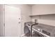 Laundry room equipped with modern washer and dryer, plus a shelf for storage at 8775 Traveling Breeze Ave # 102, Las Vegas, NV 89178