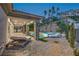 Relaxing backyard featuring a covered patio with lounge chairs, stone pillars, and a sparkling pool at 9 Rue Grimaldi Way, Henderson, NV 89011