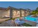 Inviting backyard with a sparkling pool, lounge chairs, covered patio, and elegant stone columns, perfect for outdoor relaxation at 9 Rue Grimaldi Way, Henderson, NV 89011