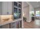 Stylish bar area with built-in wine fridge, marble countertops, and elegant gray cabinetry at 9 Rue Grimaldi Way, Henderson, NV 89011