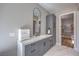 Bathroom featuring dual vanity, a modern mirror, and a view into the spacious walk-in closet at 9 Rue Grimaldi Way, Henderson, NV 89011