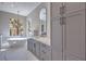 Modern bathroom with gray cabinets, marble countertops, and a freestanding tub at 9 Rue Grimaldi Way, Henderson, NV 89011