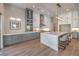 Stylish kitchen featuring gray and white cabinets, a marble island, hardwood floors, and designer lighting at 9 Rue Grimaldi Way, Henderson, NV 89011