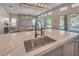 Close up of a spacious kitchen island with black faucet and a view of an open floorplan at 9 Rue Grimaldi Way, Henderson, NV 89011