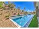 Stylish pool surrounded by rock landscaping, artificial turf, and greenery at 9 Rue Grimaldi Way, Henderson, NV 89011