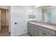 Bathroom featuring double sinks, and gray shaker cabinets, and open doorway to closet at 9086 Nostrand Ave, Las Vegas, NV 89148