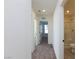 Hallway featuring neutral walls, carpet, and views into the bathroom and other rooms at 9086 Nostrand Ave, Las Vegas, NV 89148