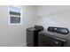 Well-lit laundry room featuring modern, dark appliances and a convenient wire shelving unit at 9086 Nostrand Ave, Las Vegas, NV 89148