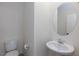 The powder room features a pedestal sink, round mirror, and ample lighting at 9086 Nostrand Ave, Las Vegas, NV 89148