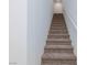 Carpeted stairway ascending to the upper level, featuring white walls and natural light at 9086 Nostrand Ave, Las Vegas, NV 89148