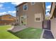 Landscaped backyard featuring artificial turf, a patio, and a sliding glass door for indoor-outdoor living at 9190 Wine Cellar Ave, Las Vegas, NV 89148