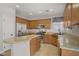 Well-lit kitchen featuring tan cabinets, granite countertops, stainless steel appliances and tile flooring at 9190 Wine Cellar Ave, Las Vegas, NV 89148
