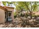 The backyard has desert landscaping, mature trees, and a cozy screened-in patio for outdoor relaxation and enjoyment at 9329 January Dr, Las Vegas, NV 89134