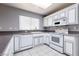 Well-lit kitchen featuring white appliances, and white tile floors at 9329 January Dr, Las Vegas, NV 89134