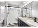 Modern bathroom features a tiled shower with a glass door, dual sinks, and updated fixtures at 9333 Jumpin Juniper Ave, Las Vegas, NV 89129