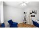 Cozy bedroom with a comfortable blue chair, a ceiling fan, and natural light, perfect for relaxation at 9333 Jumpin Juniper Ave, Las Vegas, NV 89129