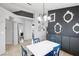 Bright dining area with a white table set, blue chairs, modern light fixture and stylish decor on an accent wall at 9333 Jumpin Juniper Ave, Las Vegas, NV 89129