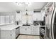 Charming kitchen features stainless steel appliances, white countertops and cabinets and a convenient breakfast bar at 9333 Jumpin Juniper Ave, Las Vegas, NV 89129