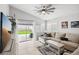 Cozy living room with neutral-toned sectional, tile flooring, and access to the backyard at 9333 Jumpin Juniper Ave, Las Vegas, NV 89129