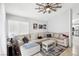 Inviting living room featuring a large sectional, modern ceiling fan, and natural light at 9333 Jumpin Juniper Ave, Las Vegas, NV 89129