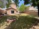 Large backyard featuring a cozy firepit area, a grass lawn, and mature trees at 11117 Okeefe Ct, Las Vegas, NV 89144