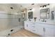 Modern bathroom with double sinks, quartz countertops, and a large tiled shower with glass door at 1312 Pacific Terrace Dr, Las Vegas, NV 89128