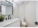 Modern powder room with marble countertop, black fixtures, and wood-style flooring at 1312 Pacific Terrace Dr, Las Vegas, NV 89128