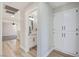 A bright hallway leads to a modern bathroom with double sinks and wood-look floors at 1312 Pacific Terrace Dr, Las Vegas, NV 89128