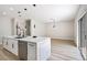 Bright kitchen with marble island, undermount sink, stainless steel dishwasher and sliding doors at 1312 Pacific Terrace Dr, Las Vegas, NV 89128