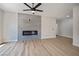 Bright living room boasts wood-style floors, a modern ceiling fan and electric fireplace with grey tile accent wall at 1312 Pacific Terrace Dr, Las Vegas, NV 89128