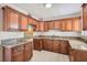 Well-lit kitchen featuring wood cabinetry, tile flooring, and granite countertops at 1404 Atlantic St, Las Vegas, NV 89104